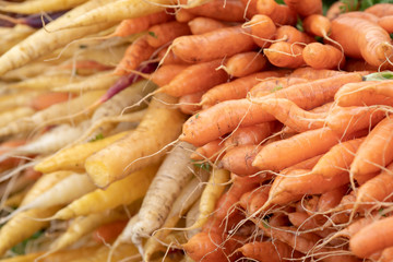 Carrots stacked in a farmer's market food stall.