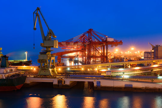 Cargo ship in port of Rizhao, China, inner harbor under deep blue twilight sky