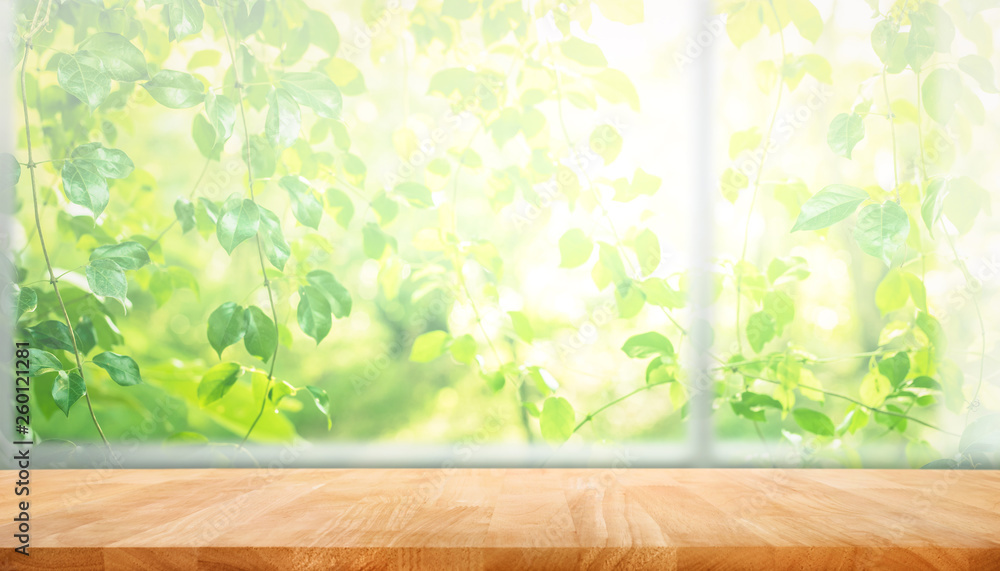 Wall mural wood table top on blur of window with garden flower background in morning