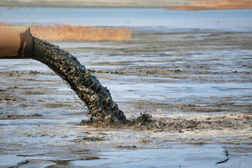 Dirty water flows from the rusty iron pipe