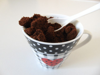 Delicious coffee grounded in cute cup for Valentines day with heart.