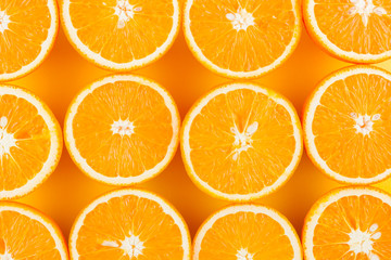 Cut halves of juicy orange on yellow background. Orange fruit, citrus minimal concept. Creative summer food minimalistic background. Top view, flat lay