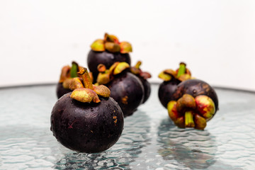 Tropical fruit mangosteen on a glass table