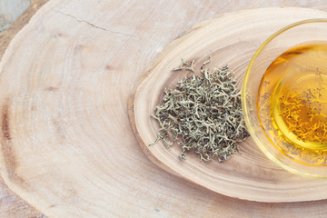 Dry grass and Herbal infusion of moss. On wooden background