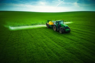 Photo sur Plexiglas Tracteur Vue aérienne du tracteur agricole labourant et pulvérisant sur le terrain