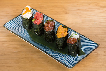 different varieties of gunkan wrapped in nori seaweed, bluefin tuna tartare, caviar of different sizes and colours avocado, sea urchin and squid