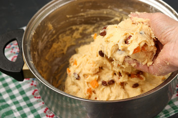 The dough with raisins and candied fruit for making Easter cakes is located in a bowl