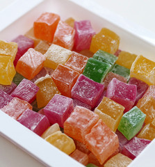 red, green, yellow and orange small Turkish delight, close up of tiny turkish delight in plate