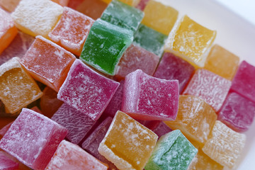 red, green, yellow and orange small Turkish delight, close up of tiny turkish delight in plate