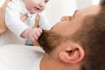 Fototapeta premium Baby infant hands grab beard of man