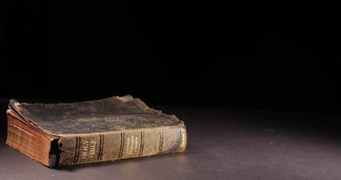 Old worn vintage book toppling onto its side