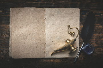 A Wish list mock up, quill pen and a golden magic lamp on a wooden board background. Fulfillment of...
