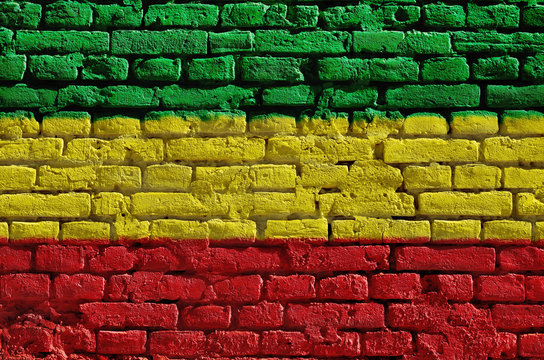 Brick wall painted in green, yellow and red. Rastaman flag.