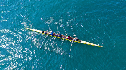 Aerial drone bird's eye view photo of yellow sport canoe operated by team of young team in emerald...