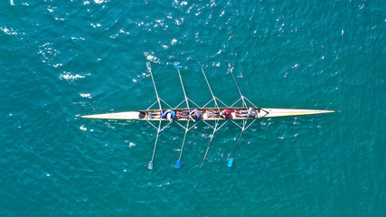 Aerial drone bird's eye view photo of yellow sport canoe operated by team of young team in emerald...