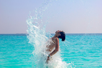 Man splashing water during summer holidays.