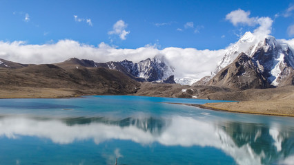 Beautiful landscape of vast sky mountain and lake with reflection of cloud in clean greenish water