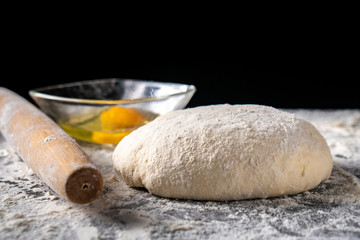White flour with eggs, butter and dough on a cooking board