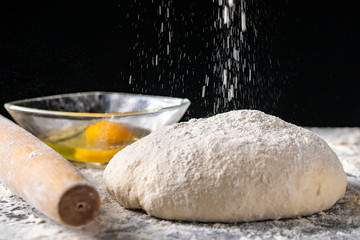 White flour with eggs, butter and dough on a cooking board