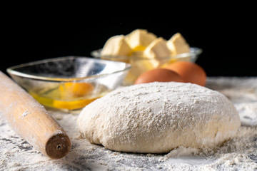 White flour with eggs, butter and dough on a cooking board