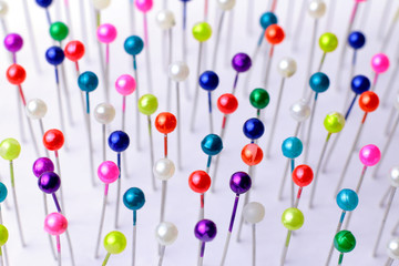 Sewing pins. Colorful sewing pins background. Close Up of sewing pins with multi colored heads....