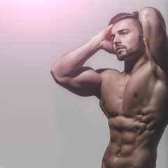 Striptease concept. Portrait of handsome guy with strong muscular body on blue background....