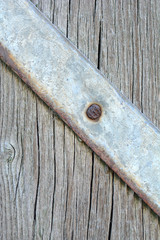 Metal plate with screws over the wooden background