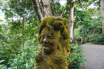 Fototapeta na wymiar The statue in Ubud Monkey Forest covered by moss, Bali Island, Indonesia