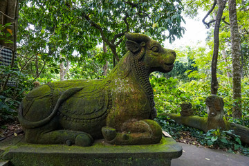 Fototapeta na wymiar The statue of goat in Ubud Monkey Forest covered by moss, Bali Island, Indonesia
