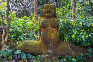 The statue of women in Ubud Monkey Forest covered by moss, Bali Island, Indonesia