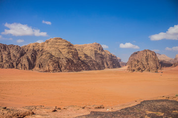 picturesque desert panorama scenic landscape wilderness nature environment with big dune yellow valley foreground and sand stone mountain ridge background summer bright vivid colorful dry weather time