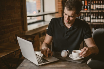 Fototapeta na wymiar Businessman working on a laptop in a cafe.