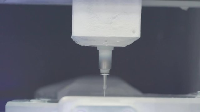 Close view of a machine 3d printing a denture.