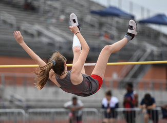 Young girls jumping high for a high jump track meet