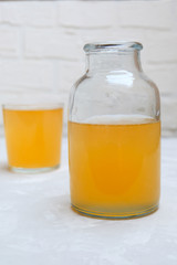 Healthy fermented kombucha tea in a jar on neutral background.