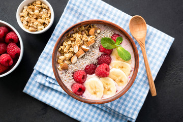 Tasty Smoothie Bowl With Berries, Granola, Chia Seeds On Blue Table Napkin, Black Background. Healthy Eating, Healthy lifestyle concept