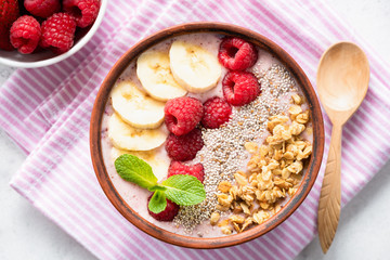 Pink Smoothie Bowl With Banana, Raspberry, Granola And Chia Seeds. Healthy Vegan or Vegetarian Smoothy bowl, Top view