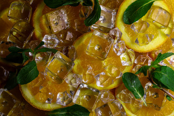 Orange, green mint leafs and ice cubes with water drops on white background.