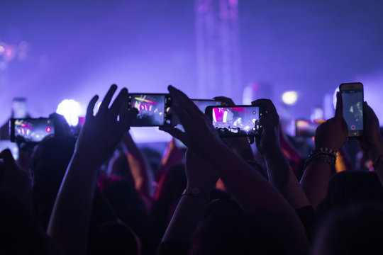 many people who dance and record with the phones at the live music concert