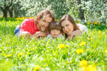 Fototapeta premium Young family lying on the grass