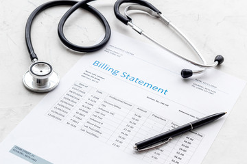 medical treatment bill and phonendoscope on white background