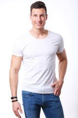 Obraz premium Studio shoot of young sport man in white shirt and jeans. 