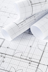 Rolls of architectural blueprint house building plans on blueprint background
