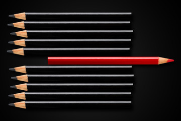 Business concept of disruption, leadership or think different; red pencil in row of black pencils...