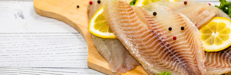 Whitefish Tilapia Fish Raw Fillet on White Wooden Background. Selective focus.