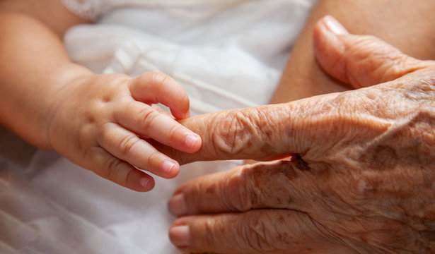 Baby holding finger from great grandmother