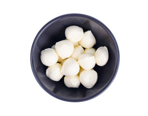 Small white mozzarella balls in black bowl.