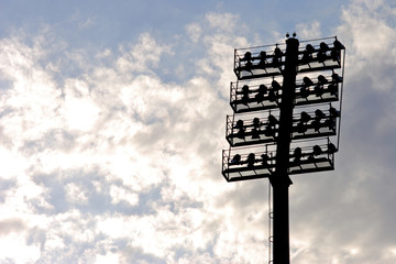 Stadium lights, silhouetted on cloudy background