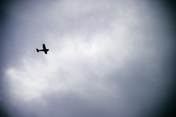 Small airplane silhouetted against a cloudy sky.
