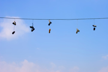 Old shoes hang on wire